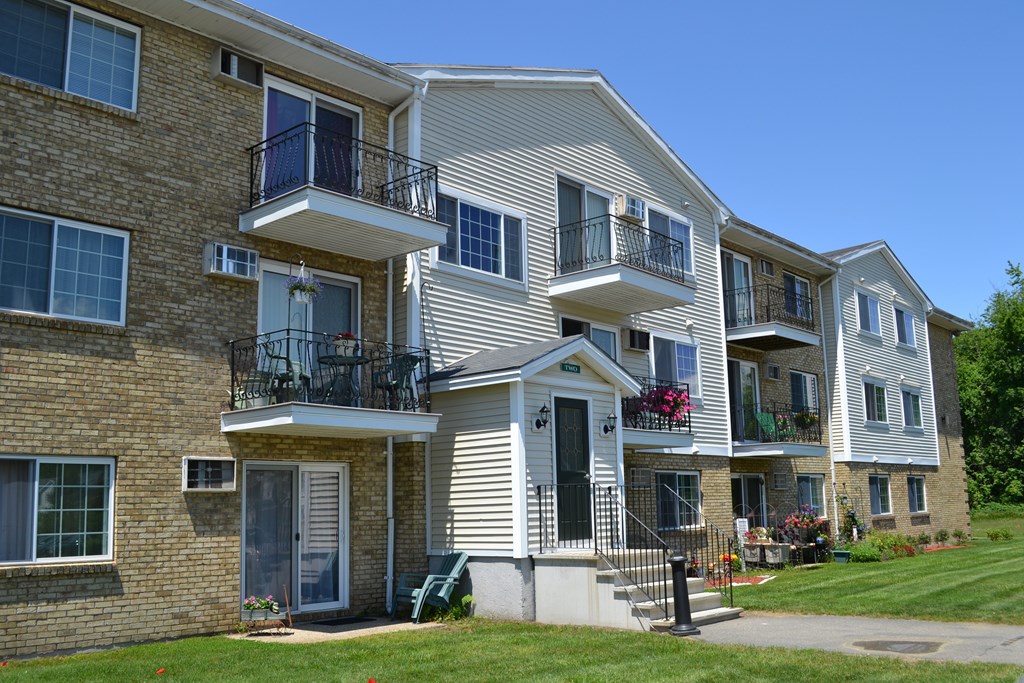 A multi-story apartment building with balconies and flower pots.