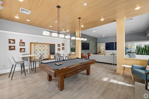 A room with a pool table and a dart board.