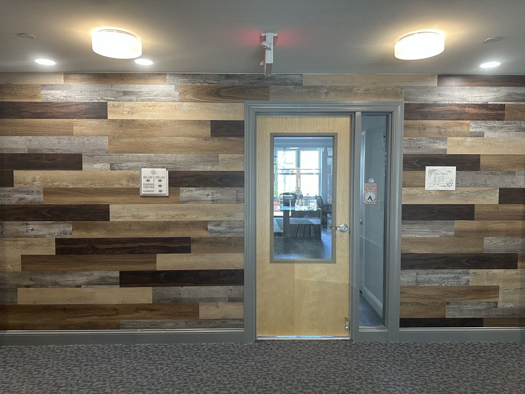 a sliding glass door in a room with a wooden wall