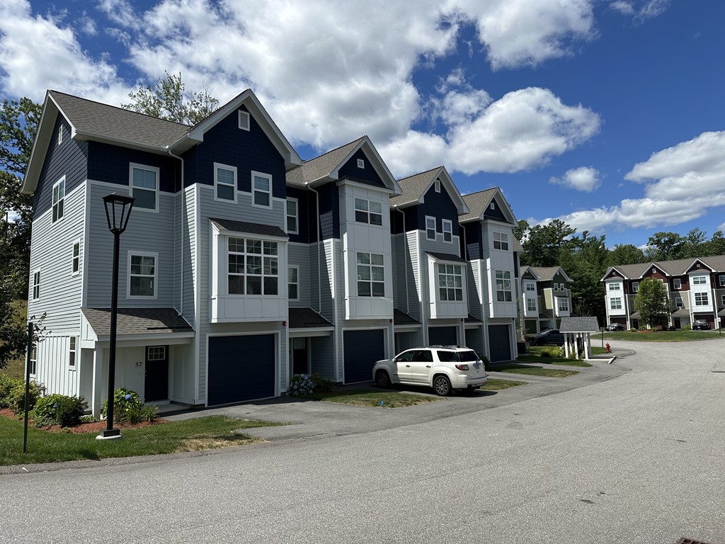 A row of houses with a car parked in front of them.