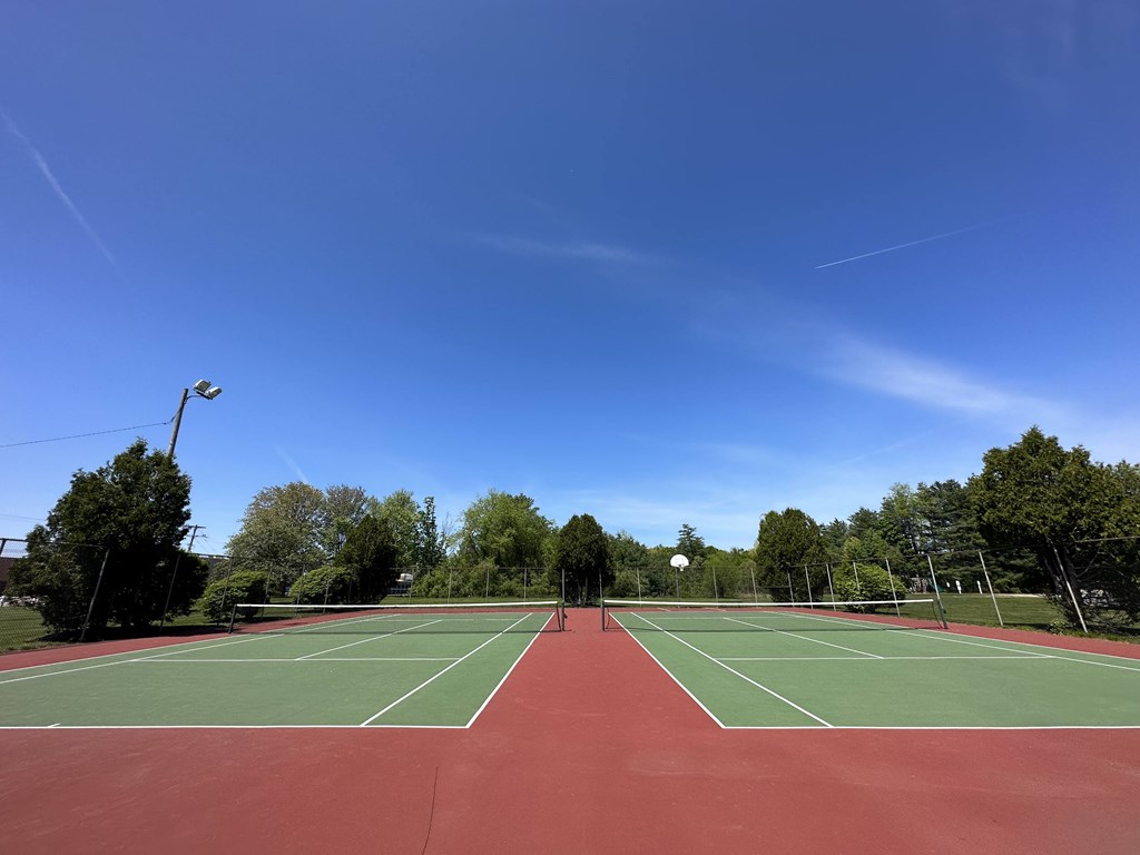 A tennis court with a net and two players on it.