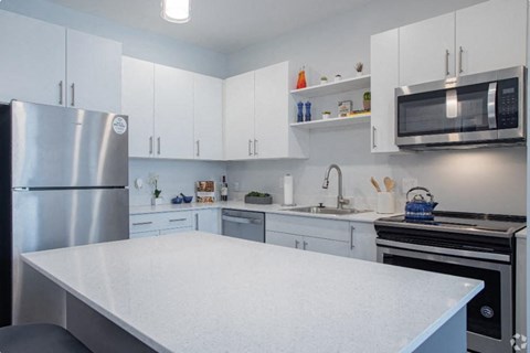 a kitchen with a white counter top and a refrigerator