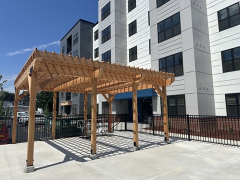 a wooden pavilion in front of a building