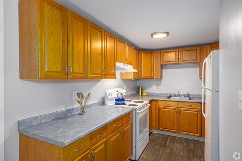 A kitchen with wooden cabinets and a white refrigerator.