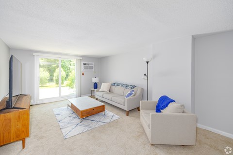 A living room with a white couch and a wooden coffee table.