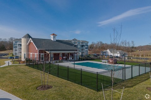 a fenced in swimming pool with a building in the background