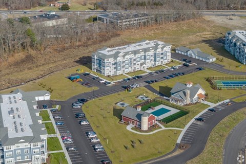 an aerial view of an apartment complex with cars parked in front of it
