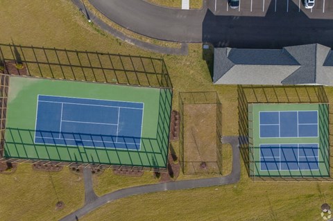 an aerial view of three tennis courts on a street