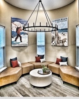 a lobby with couches and a chandelier and pictures on the wall