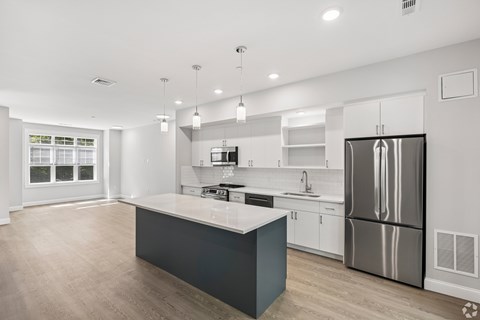 A modern kitchen with a large island and stainless steel appliances.
