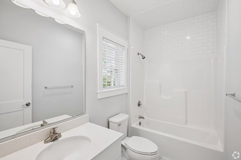 A white bathroom with a toilet, sink, and bathtub.