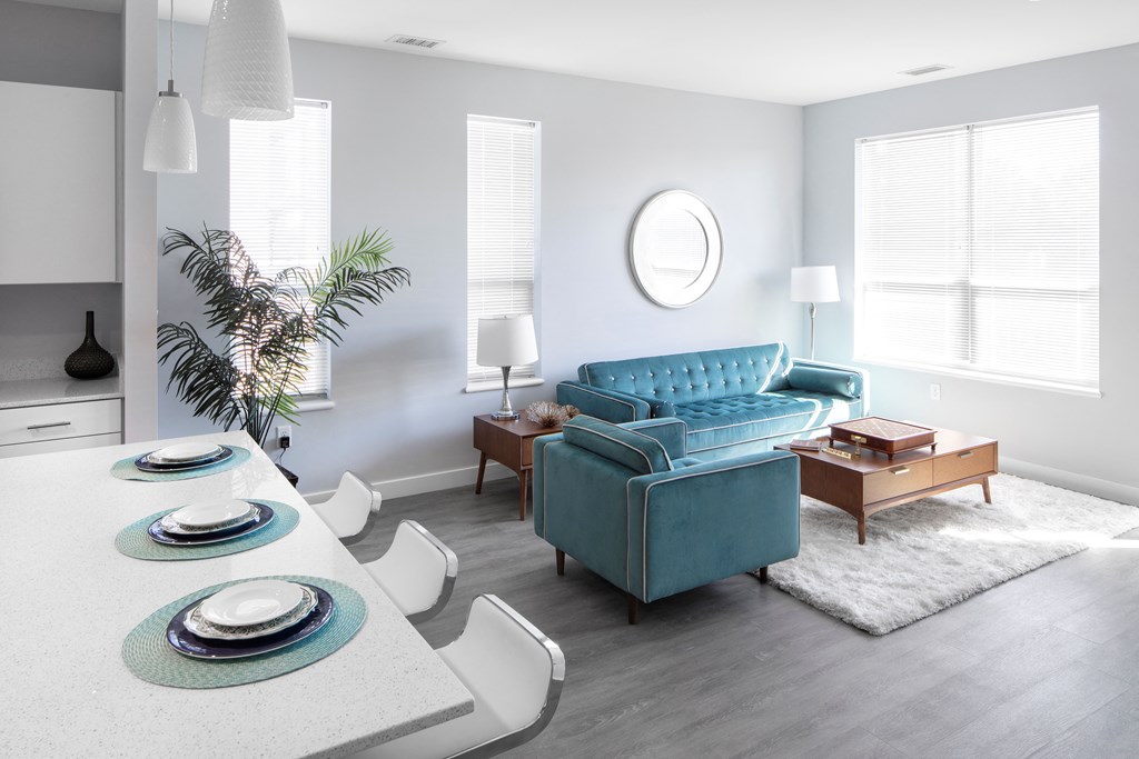 a living room with a blue couch and a table and chairs
