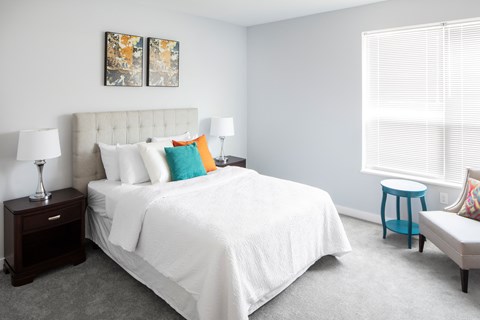a bedroom with a white bed and colorful pillows