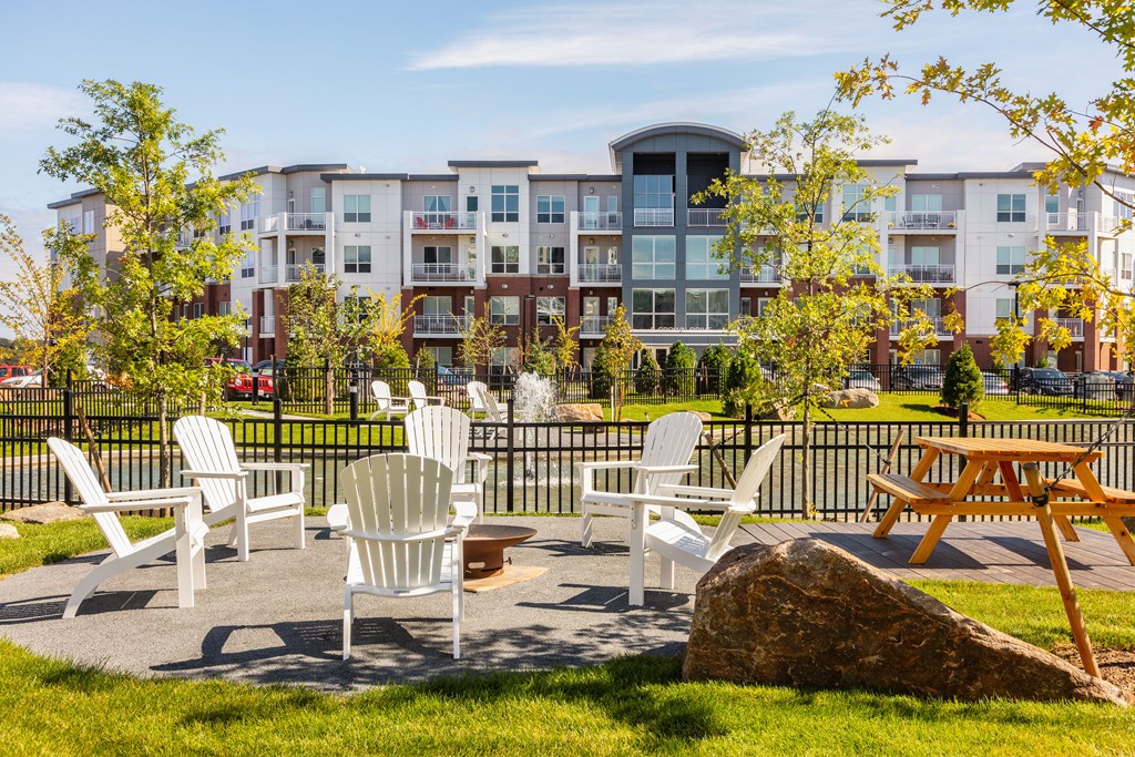 an outdoor patio with chairs and tables in front of an apartment building