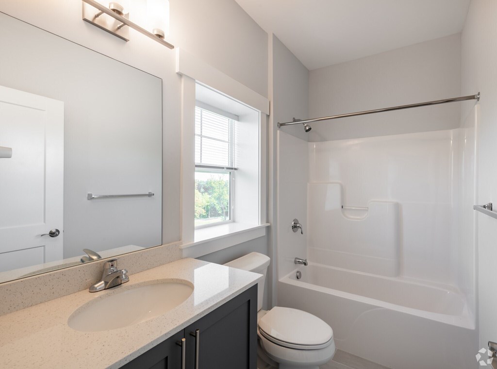 A white bathroom with a toilet, sink, and bathtub.
