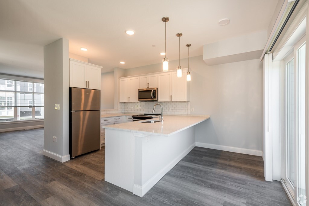 A modern kitchen with a large island and stainless steel appliances.