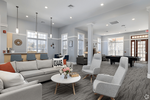 A living room with grey and white furniture and a grey carpet.