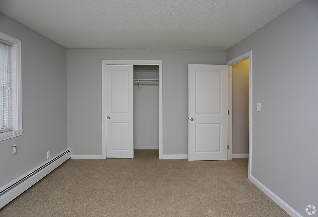 A room with two white doors and a window.