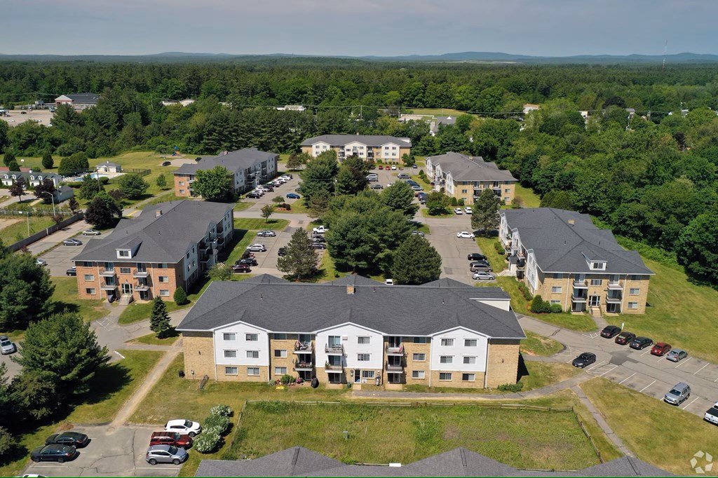 A bird's eye view of a residential area with multiple houses and cars.