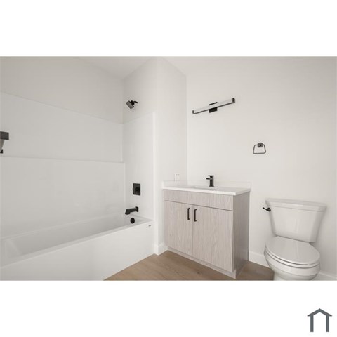 A white bathroom with a toilet, sink, and bathtub.