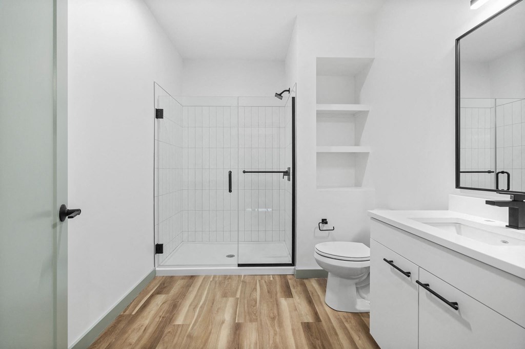 A white bathroom with a walk-in shower and a toilet.