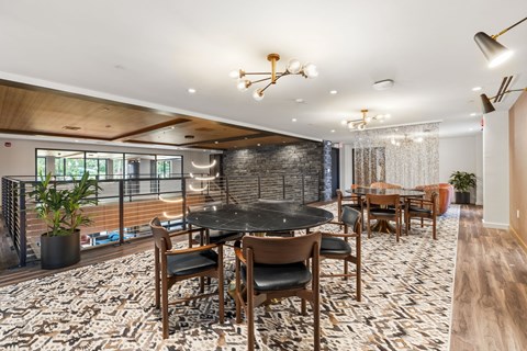 A dining room with a black table surrounded by wooden chairs.