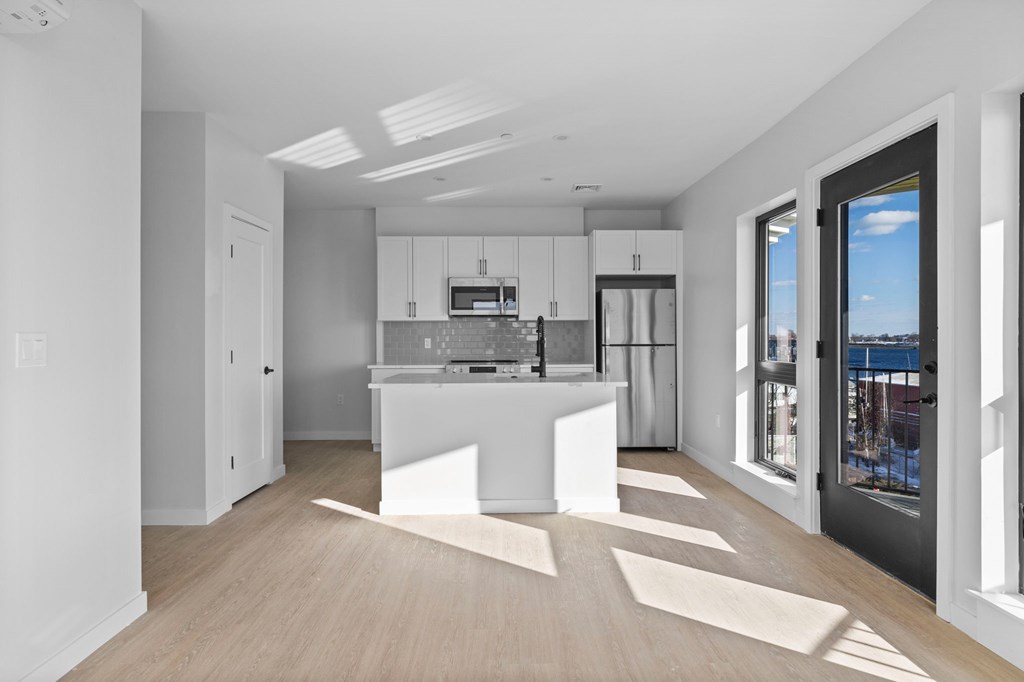 A modern kitchen with white cabinets and a large island.
