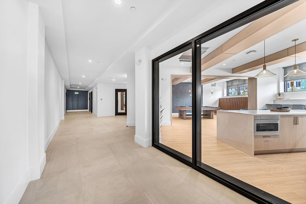 A long hallway with a kitchen in the background.