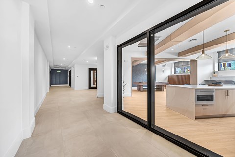 A long hallway with a kitchen in the background.