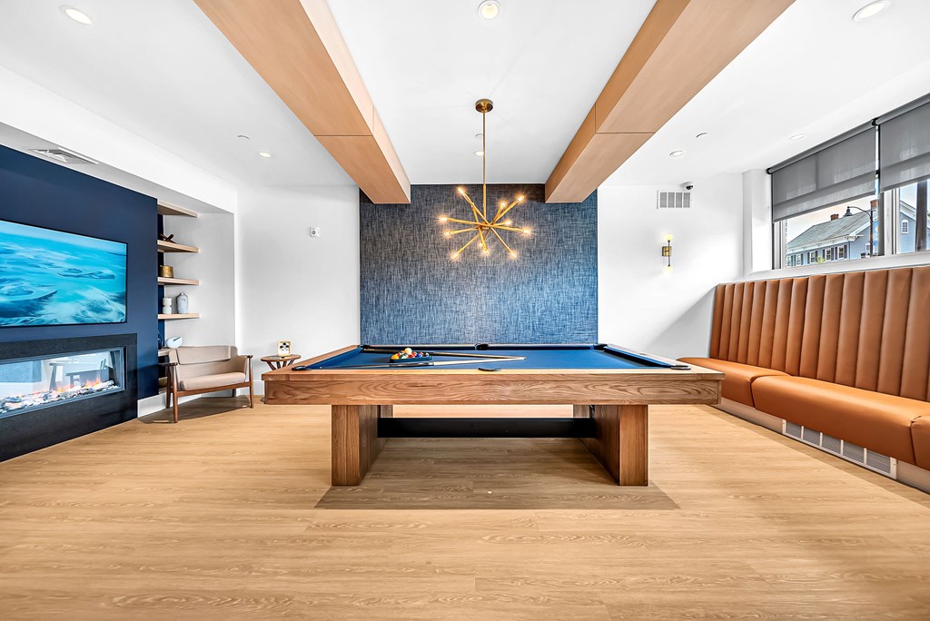A room with a pool table and a television.
