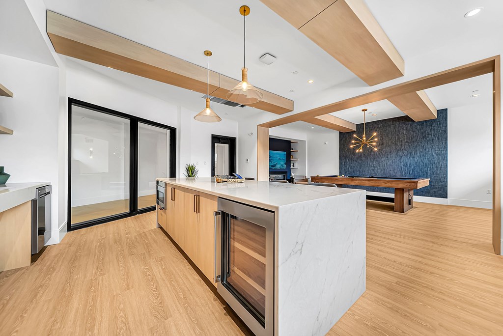A modern kitchen with wooden floors and a central island.