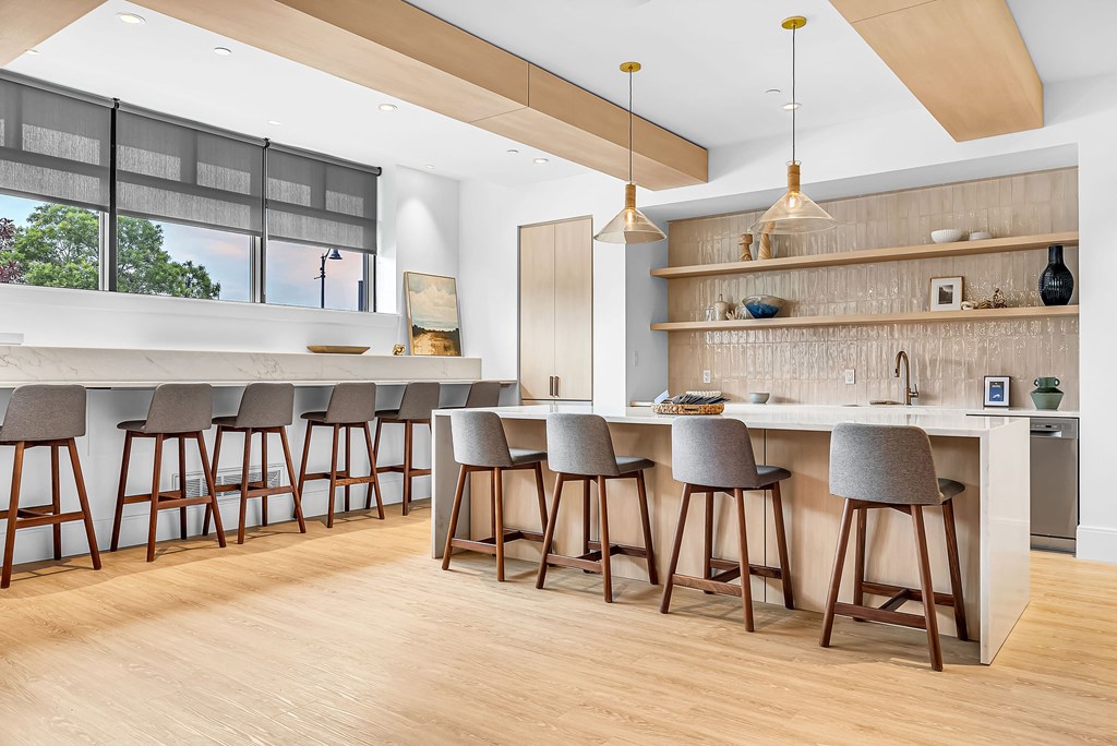 A kitchen with a bar area and wooden floors.