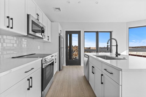 A modern kitchen with white cabinets and a black oven.