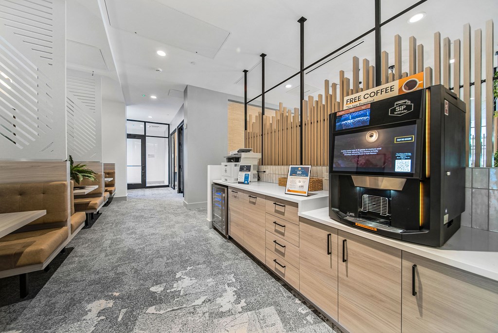 A modern coffee shop with a black coffee machine and wooden furniture.