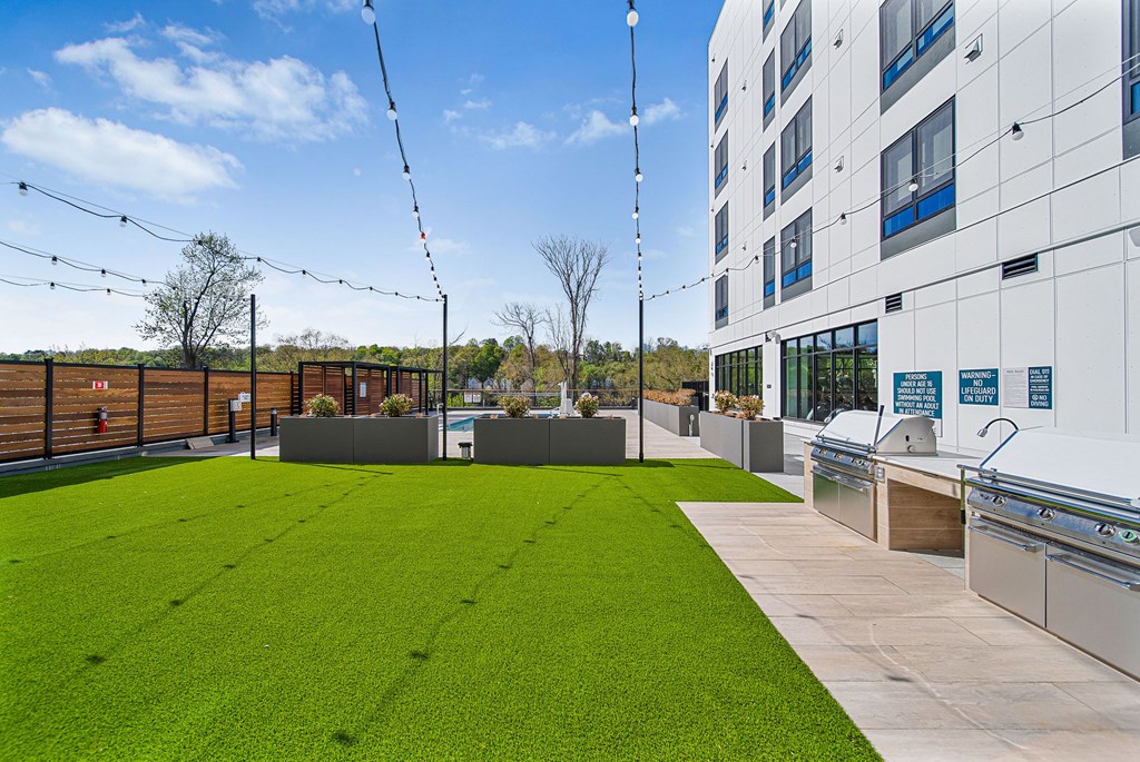 A grassy area in front of a building with a clear blue sky.