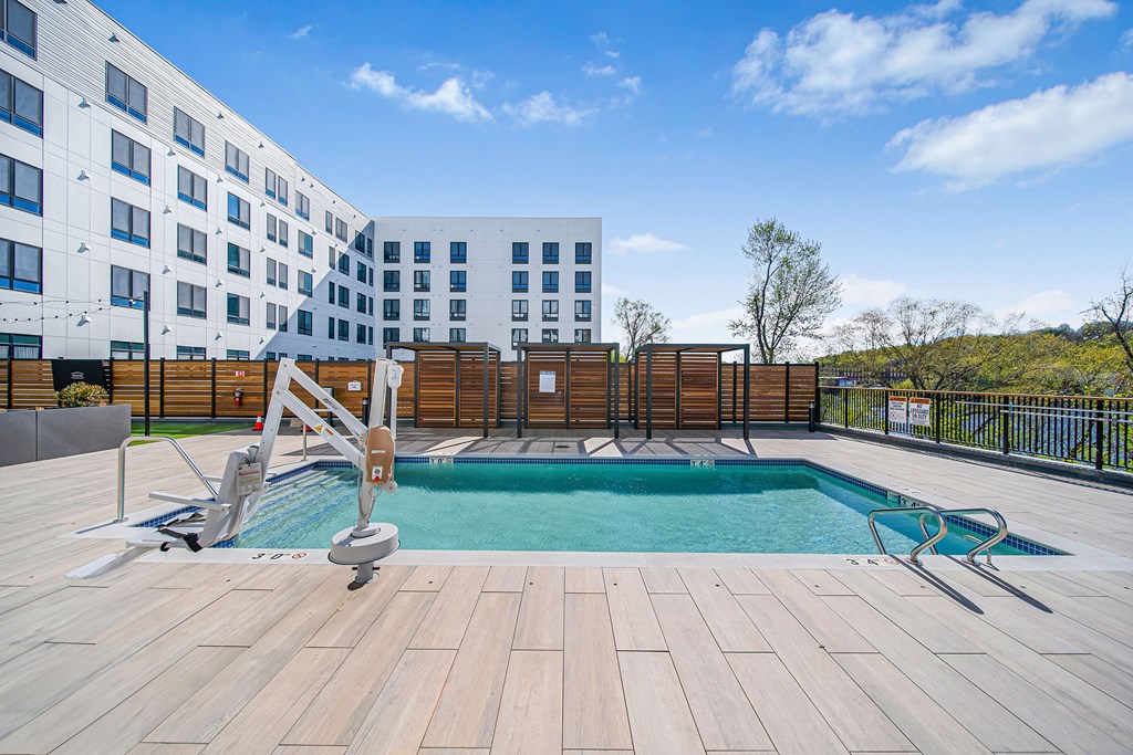 A wooden deck with a pool and a slide.