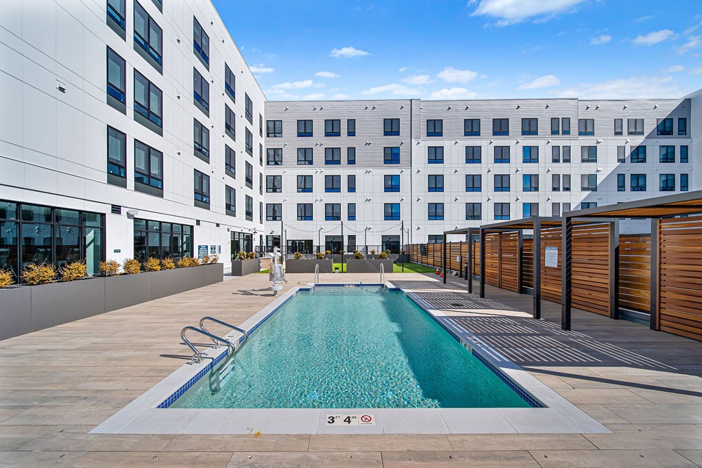 A swimming pool in front of a white building.