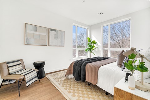 A bedroom with a large bed and a chair.