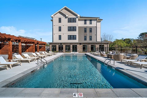 A large building with a pool in front of it.