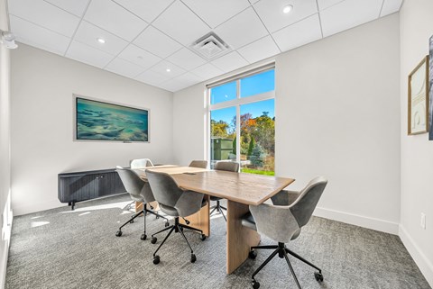 A conference room with a large table and chairs.