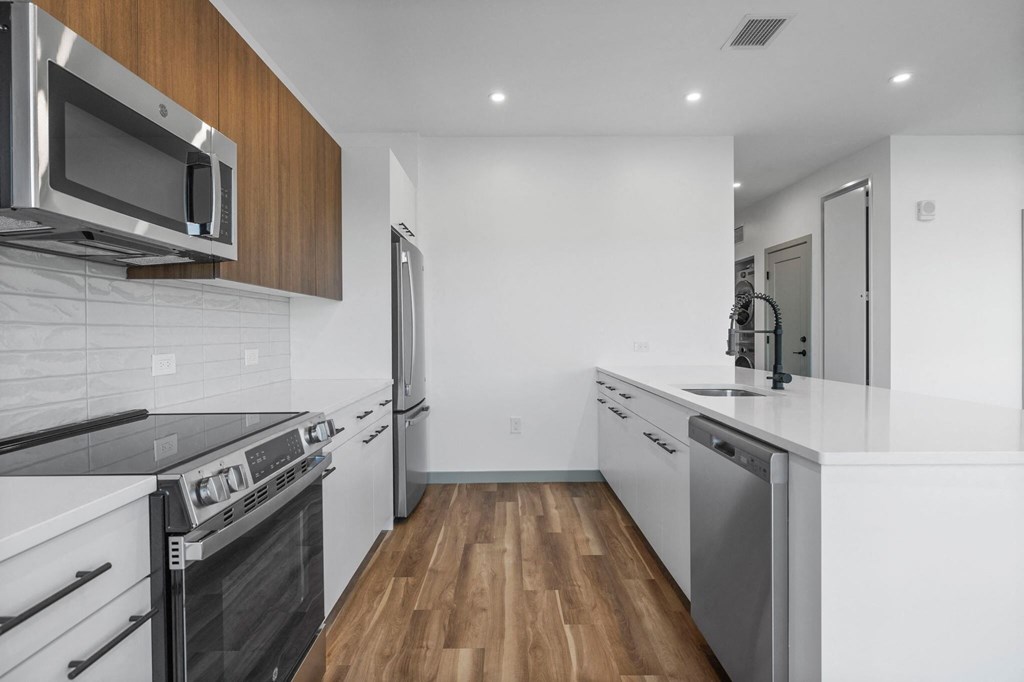 A modern kitchen with stainless steel appliances and wooden cabinets.