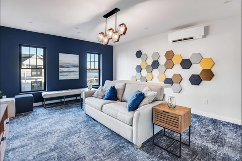 a living room with a couch and a blue rug