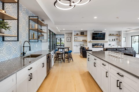 a large kitchen with white cabinets and a living room