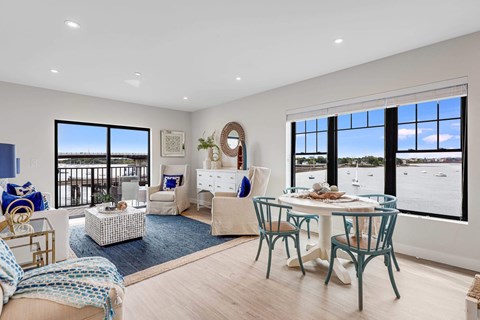a living room and dining room with a view of the water