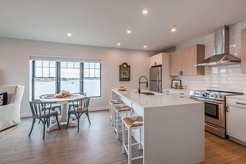 a kitchen with a large island and a table with chairs