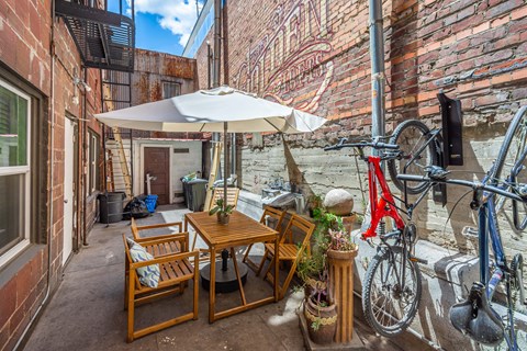 A patio with a table and chairs and a bicycle.