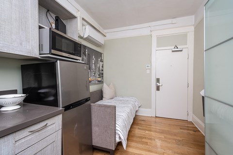 A kitchen with a refrigerator, microwave, and oven.