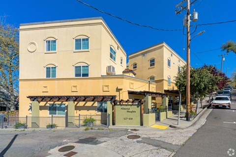 A yellow building with a sign that reads "Almonds" is located on a street corner.