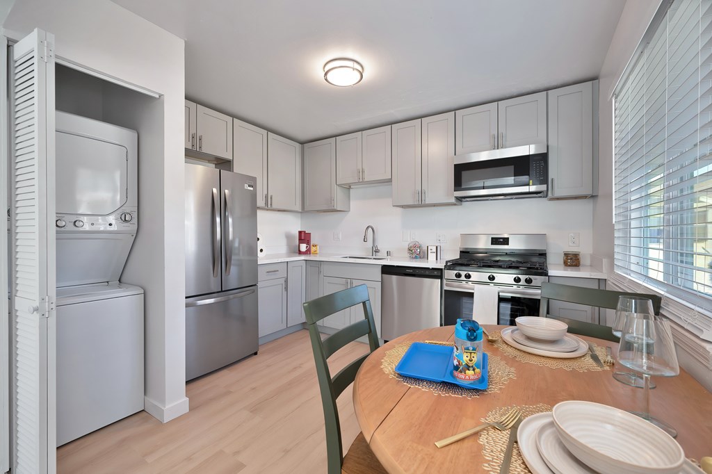 A kitchen with a table set for two with a blue plate.