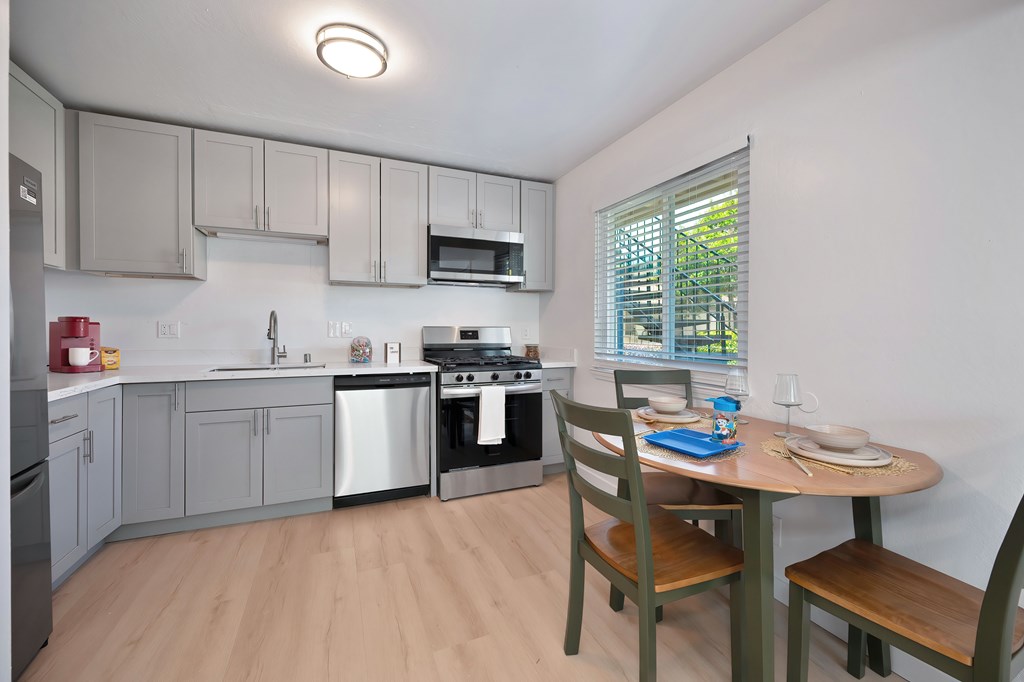 A kitchen with a table and chairs.